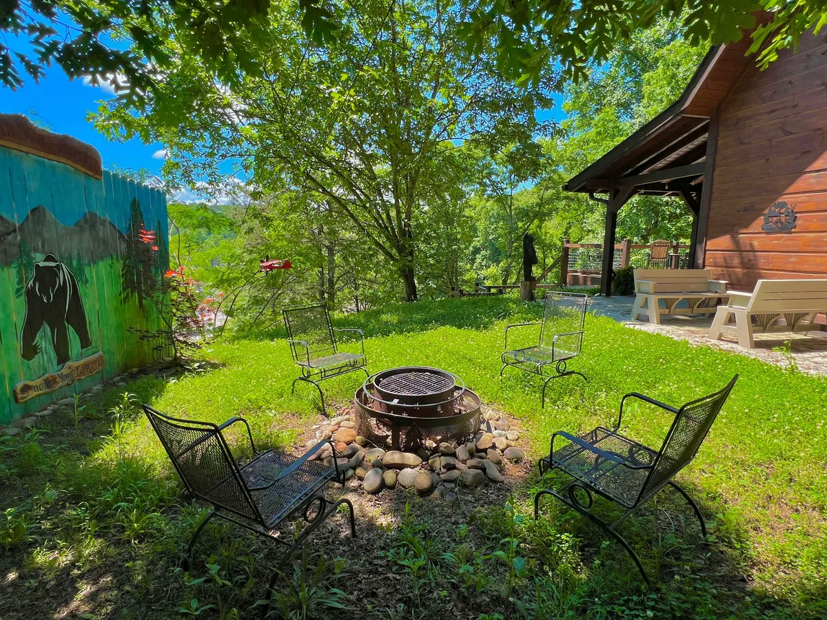 This image shows an inviting fire pit area surrounded by chairs, set in front of a wooden cabin with a colorful mural. The communal setup is ideal for evening gatherings and storytelling under the stars, and the mural adds a unique, playful touch to the outdoor space.